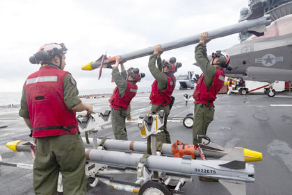 Lifted to Load: Marines prepare to carry an AIM-9X-2 missile during an ordnance load aboard the USS America in the Coral Sea, June 29, 2025.USMC photo by Sgt. Peter Rawlins